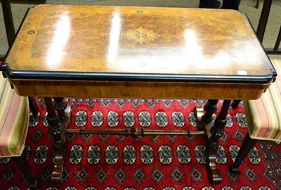 Lot 1341 - A 19th century part ebonised and inlaid burr walnut fold over card table, on a turned trestle base