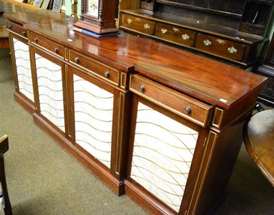 Lot 1374 - Mahogany breakfront sideboard with brass and fabric panelled doors and four frieze drawers