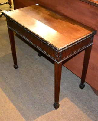 Lot 1376 - A late 19th/early 20th century mahogany fold-over tea table, carved frieze, tapered legs