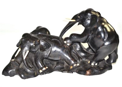 Lot 36 - An ebony and bone group of two elephants on a rocky moulded base, 38cm diameter