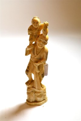 Lot 106 - A Japanese ivory okimono, early 20th century, fisherman holding a boy on his shoulders, 21cm high