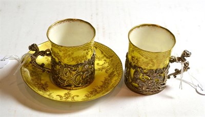 Lot 114 - Two porcelain coffee cans with silver mounts, one with a saucer