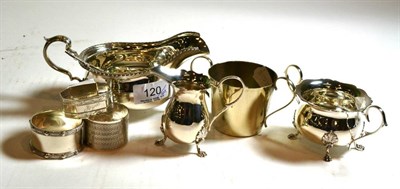 Lot 120 - A silver sauce boat, silver souvenir spoon, three silver napkin rings, silver cream and sugar and a