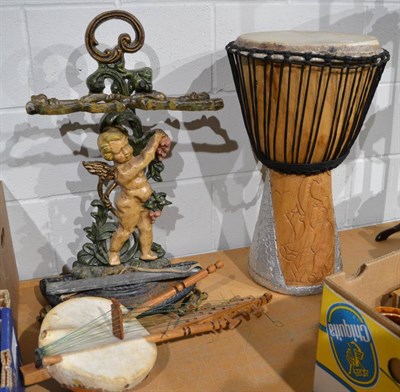 Lot 1004 - Large native Africa drum, stringed instrument and a cast iron cherub stick stand with drip tray