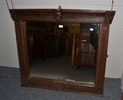 Lot 1032 - A carved wall mirror, the oak frame with 17th century style carvings of flowers and masks