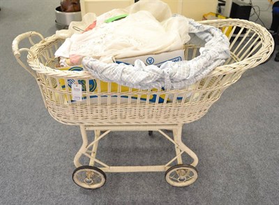 Lot 1079 - An early 20th century wicker basket pram, wedding dress, nursery and other linen