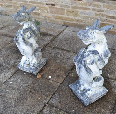 Lot 1157 - A pair of stone standing griffin and shield garden ornaments