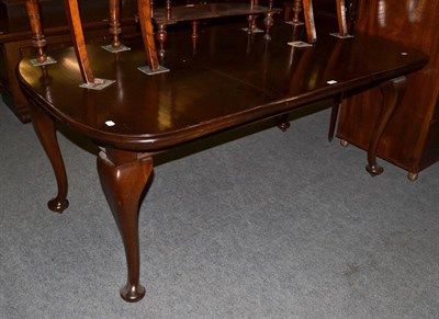 Lot 1189 - Mahogany wind out dining table with one additional leaf, raised on shallow cabriole legs...