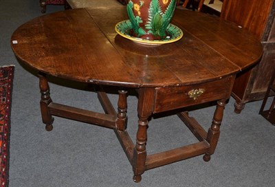 Lot 1222 - An early 18th century six-seater oak double gateleg table, with two rounded drop leaves above a...