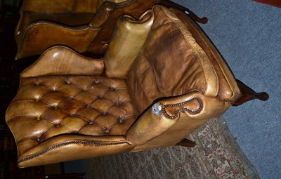 Lot 1247 - A wing back armchair upholstered in olive green leather