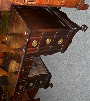 Lot 1259 - A stinkwood desk fitted six small drawers around a shaped apron and raised on claw and ball feet