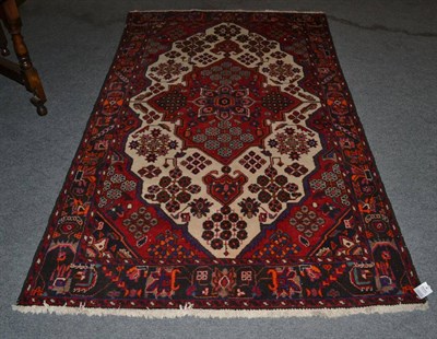 Lot 1315 - A Hamadan rug, Kurdistan, the cream field centred by a raspberry medallion framed by floral borders