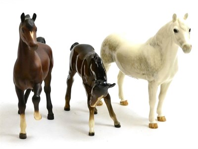 Lot 21 - Beswick horses comprising Connemara pony, grey gloss, bay foal and Prancing Arab, bay matt (3)