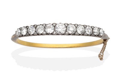 Lot 191 - A Diamond Bangle, graduated old cut diamonds spaced by old cut diamond accents in a carved setting