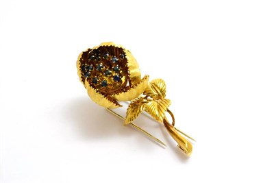 Lot 82 - A floral brooch, en tremblant, with sapphires on stalks to the centre of the stylised flower...