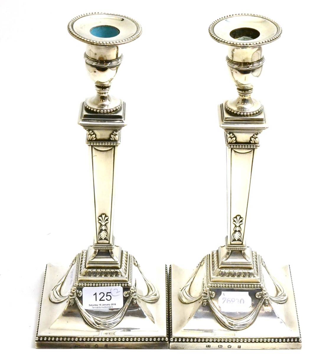 Lot 125 - A pair of George III neo classical silver candlesticks, Sheffield 1778, with removable nozzles (2)