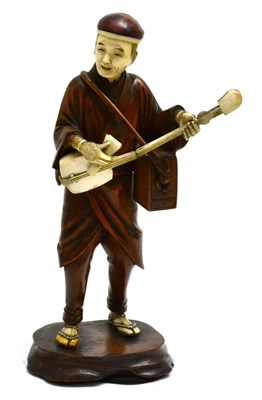 Lot 137 - A Japanese carved wood and ivory Okimono, Meiji period, of a musician