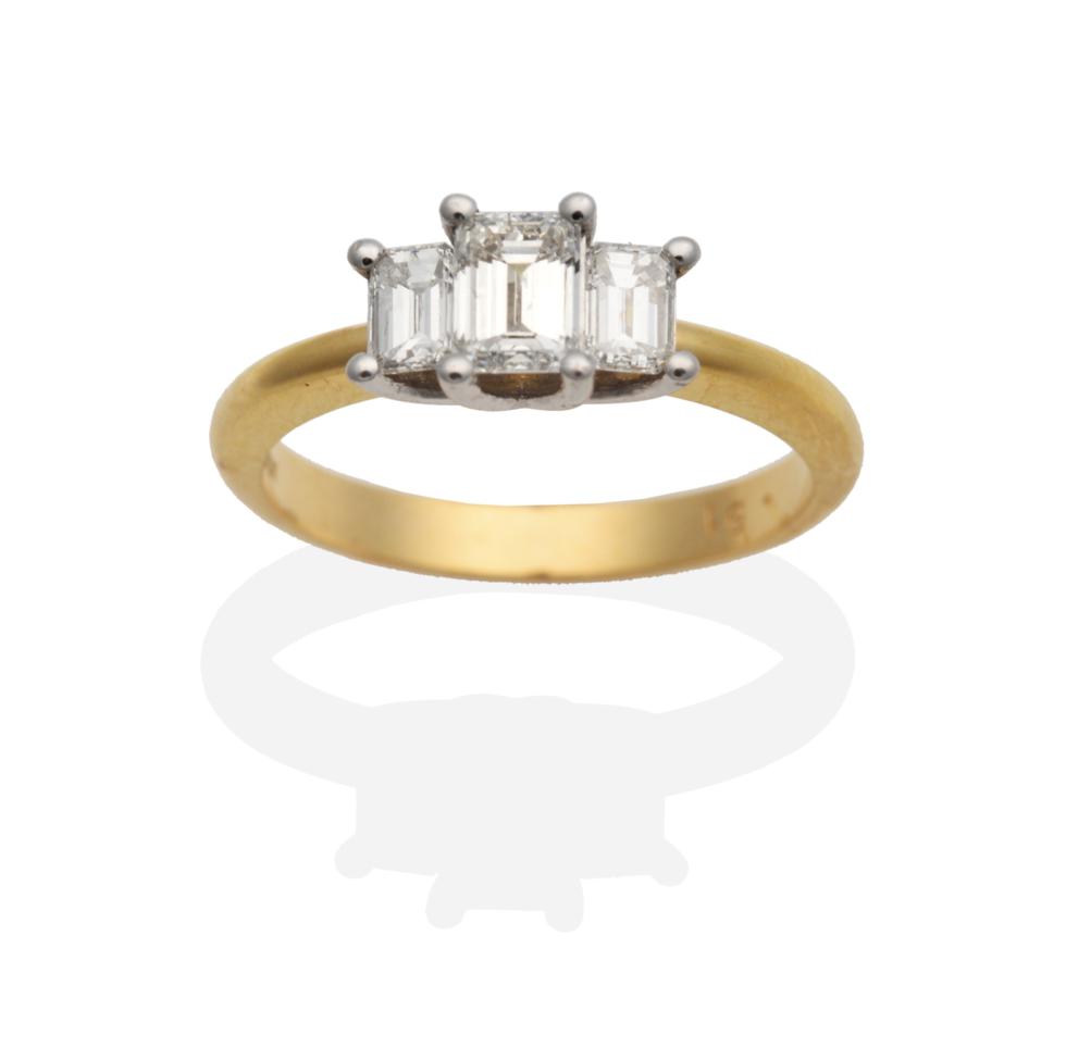 Lot 205 - An 18 Carat Gold Diamond Three Stone Ring, graduated octagonal cut diamonds in claw settings to...