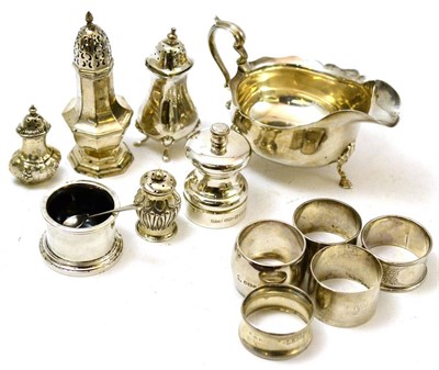 Lot 234 - A group of silver including five napkin rings, mustard, sauce boat, three pepperettes, caster and a