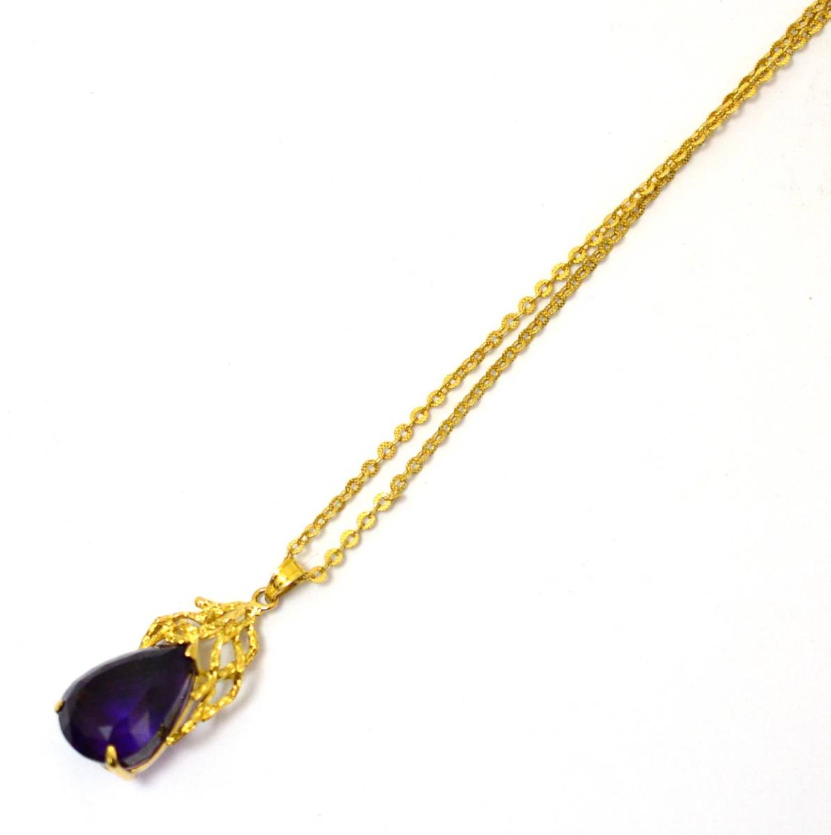 Lot 252 - An amethyst pendant on chain, a pear cut amethyst in a yellow three claw setting with a...