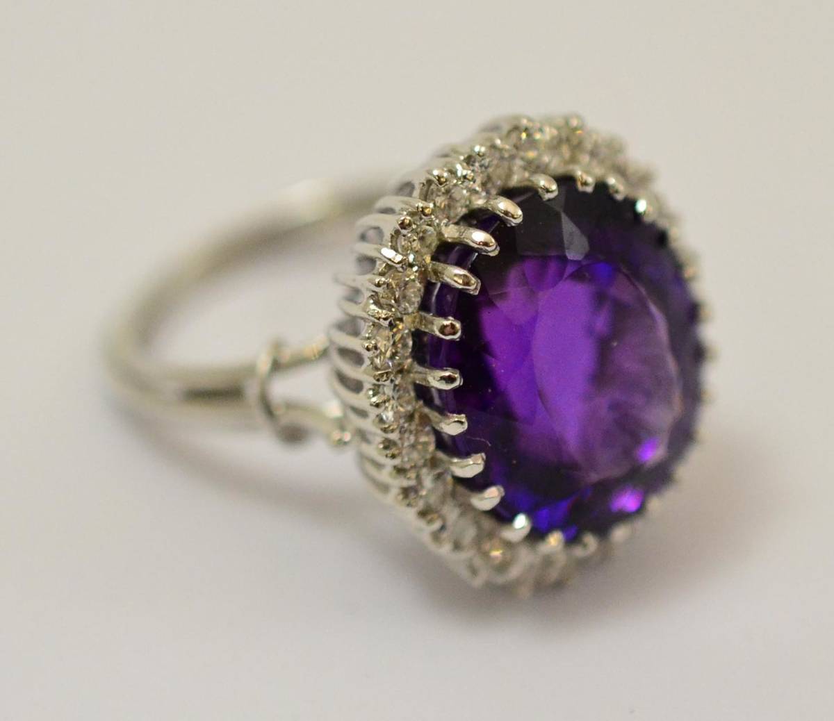 Lot 255 - An amethyst and diamond cluster ring, an oval cut amethyst within a border of round brilliant...