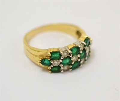 Lot 264 - An emerald and diamond ring, three rows of alternating oval cut emeralds and round brilliant...