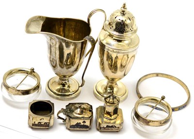 Lot 305 - A silver helmet cream jug and a silver sugar sifter with the same date letter, etc