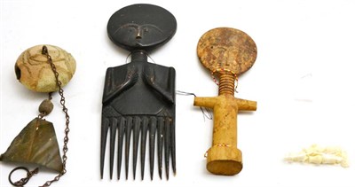 Lot 344 - A collection of miniature ivory cups, circa 1900, an African comb, bell and fertility figure