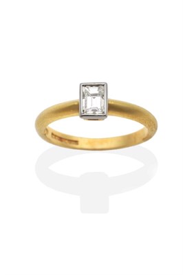 Lot 235 - An 18 Carat Gold Baguette Cut Solitaire Diamond Ring, in a rubbed over setting, to straight...