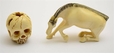 Lot 392 - A 19th century carved ivory skull, signed; and a 19th century ivory horse (2)