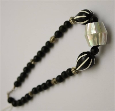 Lot 417 - A black bead and mother-of-pearl necklace