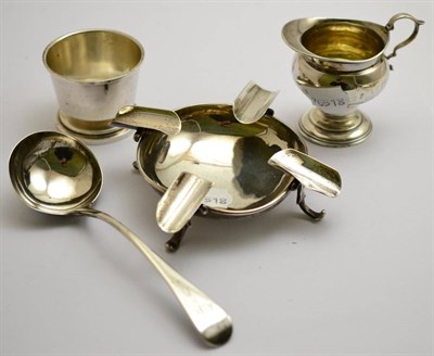 Lot 451 - A silver cream jug, ashtray, George III sauce ladle and an art deco dish (4)