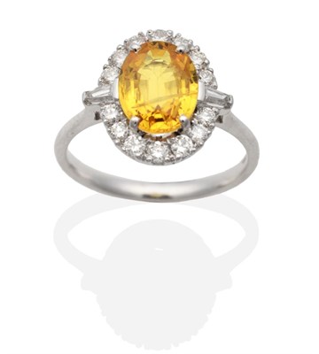 Lot 265 - An 18 Carat White Gold Yellow Sapphire and Diamond Cluster Ring, an oval cut yellow sapphire in...
