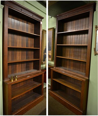 Lot 1199 - A pair of George III style mahogany bookcases, with rosette carved fluted frieze and fluted...