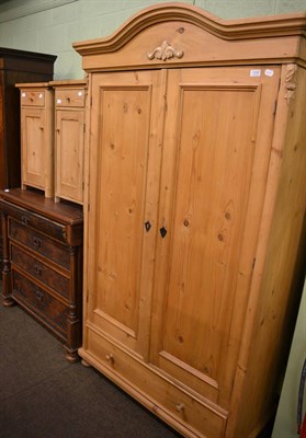 Lot 1206 - A pine wardrobe together with a pair of pine bedside cupboards