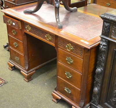 Lot 1245 - An early 20th century pedestal desk with blind fret carving to the top