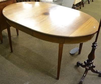 Lot 1251 - An oval mahogany dining table on reeded legs