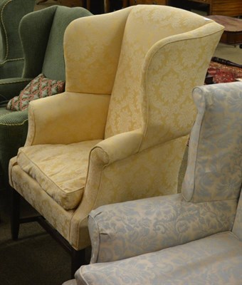 Lot 1263 - A 19th century wingback armchair with mahogany legs and pale yellow brocade covering