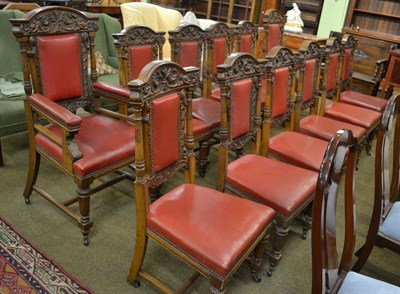 Lot 1265 - A set of twelve carved oak boardroom/dining chairs with red leather upholstery including two...