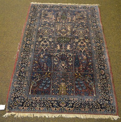 Lot 1335 - A Khorasan rug, East Persia, the aubergine compartmentalised field of trees and plants enclosed...