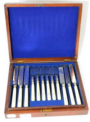 Lot 67 - A set of twelve fruit knives and forks, with crested ivory handles, late 19th century, mahogany...