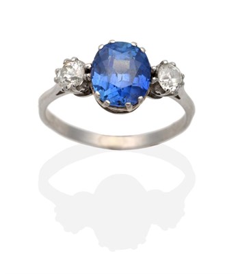 Lot 313 - A Sapphire and Diamond Three Stone Ring, an oval cut sapphire in a double claw setting, between old