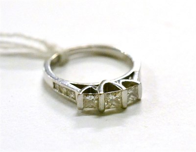 Lot 285 - A three stone princess cut diamond ring with diamond set shoulders (with original receipt)