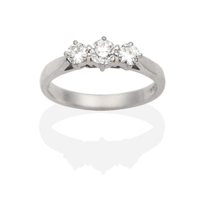 Lot 336 - A Platinum Diamond Three Stone Ring, round brilliant cut diamonds in claw settings, to knife...
