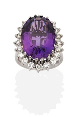 Lot 338 - An 18 Carat White Gold Amethyst and Diamond Cluster Ring, an oval cut amethyst in a claw...