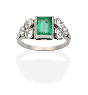 Lot 339 - An Art Deco Emerald and Diamond Ring, a baguette cut emerald in a rubbed over setting, spaced...