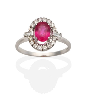 Lot 340 - An 18 Carat White Gold Ruby and Diamond Cluster Ring, an oval cut ruby in a claw setting,...