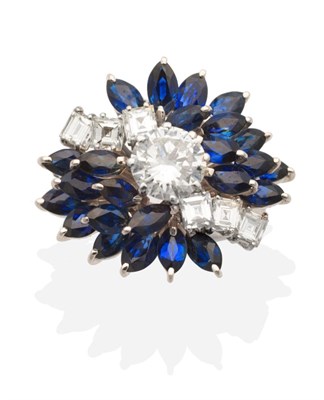 Lot 342 - A Diamond and Sapphire Cluster Ring, a central round brilliant cut diamond in a claw setting...