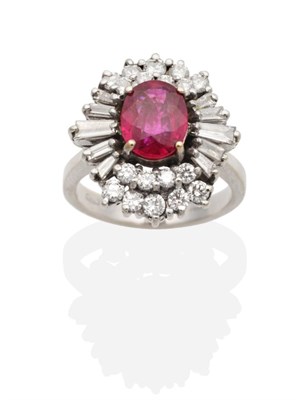 Lot 346 - A Ruby and Diamond Cluster Ring, an oval cut ruby in a claw setting, within a two tier border...