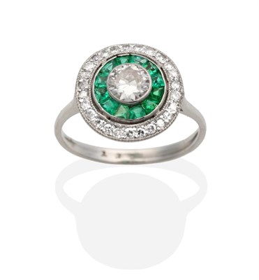 Lot 352 - An Art Deco Diamond and Emerald Ring, a central old cut diamond in a rubbed over setting within...